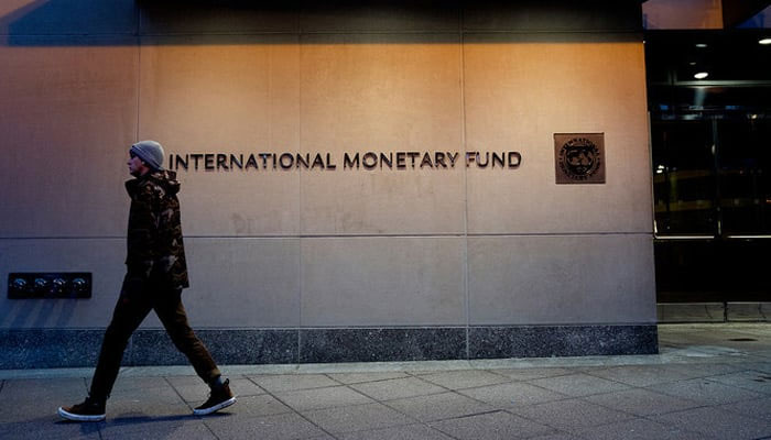 A pedestrian walks past the International Monetary Fund headquarters in Washington, DC. — AFP/File