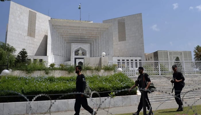 Supreme Court (SC) building can be seen as security personnel pass by. — AFP/File