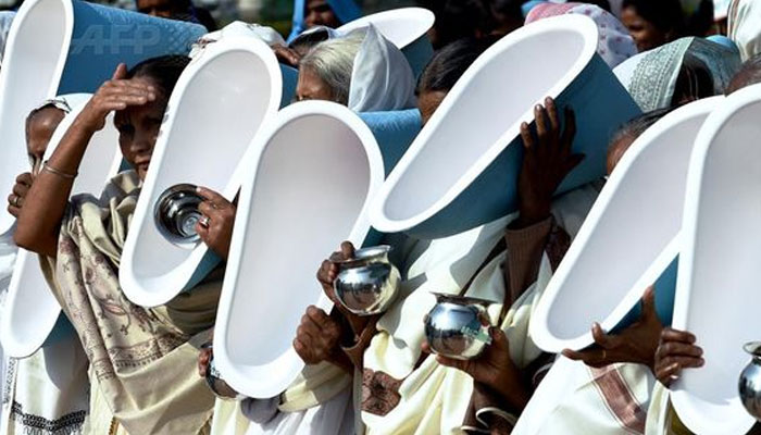 Women hold latrines during the opening ceremony of the three-day International Toilet Festival, in New Delhi. —AFP File