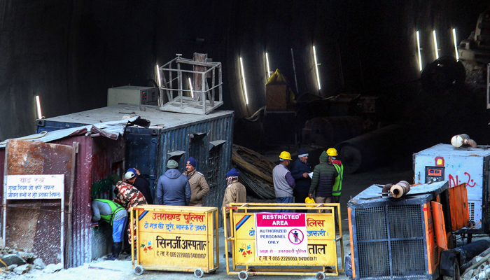 Police and officials stand at the entrance of the under-construction road tunnel that collapsed in Uttarkashi district of Uttarakhand state on November 17, 2023. — AFP