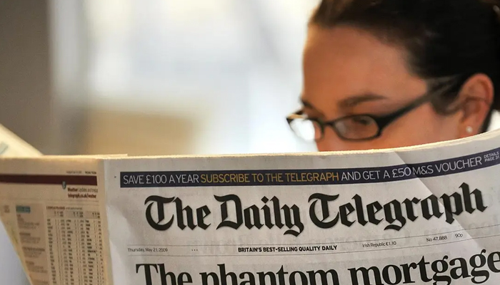 A woman reads a copy of the Daily Telegraph newspaper in London. — AFP/File