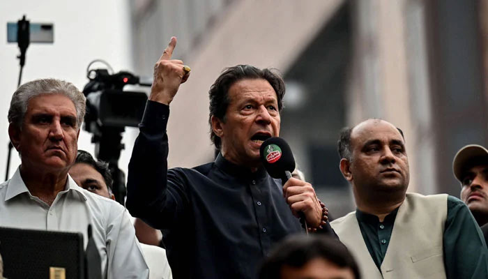 PTI Chairman Imran Khan, flanked by partys senior leader Shah Mehmood Qureshi, can be seen addressing a public gathering in this undated picture. — AFP/File