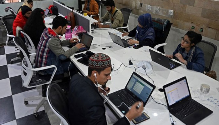 In this picture taken on January 8, 2022, employees of Taza Transforming Agriculture talk with customers at a call centre in Lahore, Pakistan. — AFP