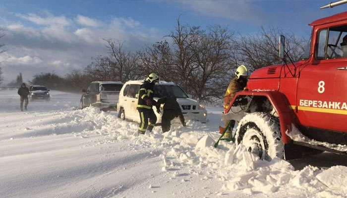 Rescuers help drivers trapped in the Mykolayiv region following heavy snowfall on November 27. . — AFP