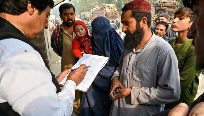 The UNHCR prepares Afghan refugees for verification at the United Nations High Commissioner for Refugees Azakhel Voluntary Repatriation Centre in Nowshera on November 23, 2023. — AFP