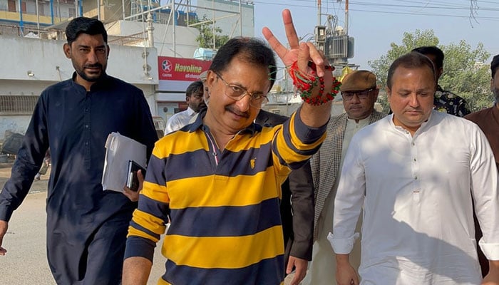 Sindh PTI president, Haleem Adil Sheikh (c) shows a victory sign on December 2, 2023, —Facebook/Haleem Adil Sheikh