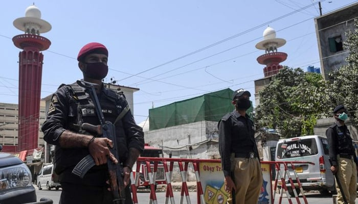 Sindh police personnel standing guard on a street. — AFP/File