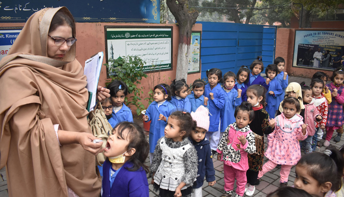 A lady health worker administers polio drops to students at school during a polio eradicating campaign, in Lahore on November 27, 2023. — Online