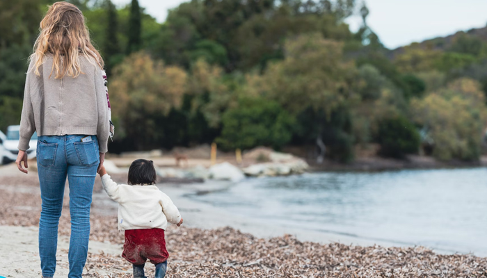This representational image shows a woman walking with a child. — Unsplash/File