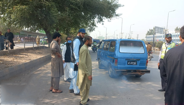 This image shows a vehicle emitting smoke as KP officials stand and observe on November 6, 2023. — Facebook/Environmental Protection Agency Govt of Khyber Pakhtunkhwa