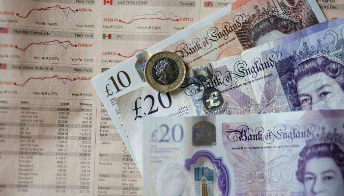 Sterling pound banknotes and coins displayed on a table in London, UK, April 22, 2022. — AFP