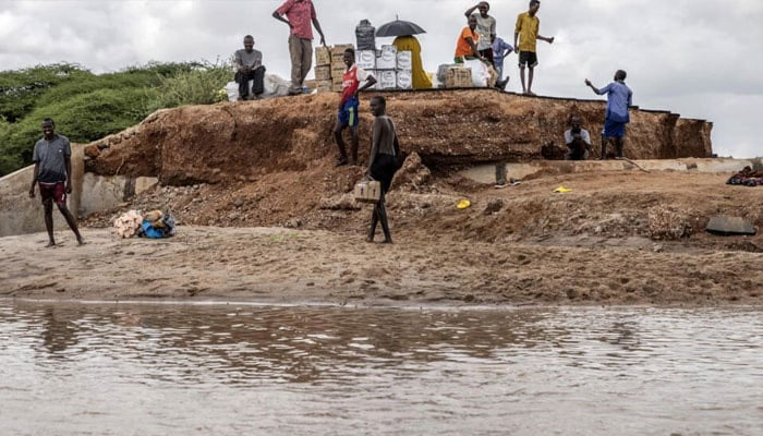 People stands near floods area in Kenya. — AFP/File