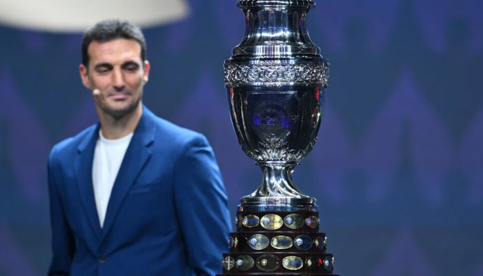 Argentina coach Lionel Scaloni eyes the Copa America trophy during the final draw for the 2024 tournament in Miami on Thursday. — AFP File