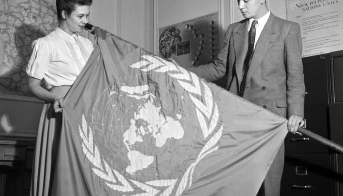 UN employees unfold a UN flag at the start of the third General Assembly of the United Nations in 1948 at the close of which was adopted on December 10 the Universal Declaration of Human Rights. — AFP File