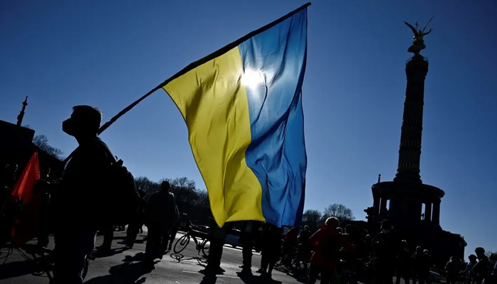 A protester holds a Ukrainian flag during a demonstration against Russias invasion of Ukraine, near the Victory Column in Berlin. — AFP/File