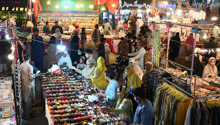 People shop at a market in Islamabad. — AFP/File