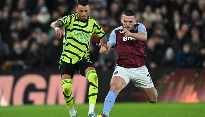 Arsenals Ben White (L) fights for the ball with Aston Villas John McGinn during the English Premier League football match between at Villa Park in Birmingham, on December 9, 2023. — AFP