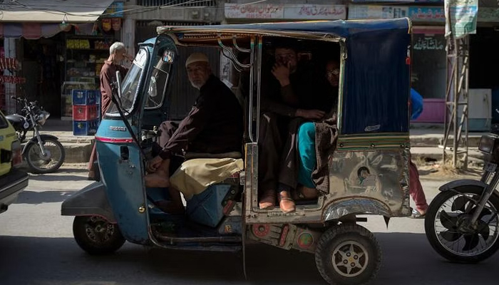 This representational image shows a rickshaw driver carrying passengers in Rawalpindi. — AFP/File