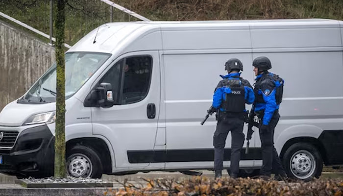 Police officers control a vehicle near Saint Maurice, as they search for a gunman who killed two people and injured another in the southern Swiss town of Sion, on December 11, 2023. — AFP