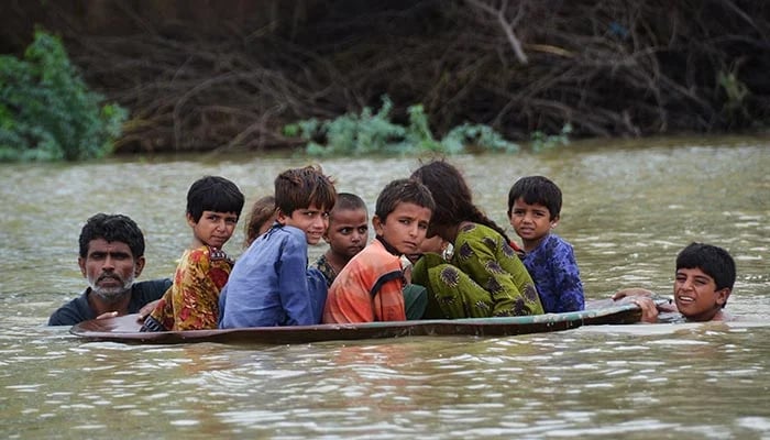 A man rescues his children during flooding in Sindh. — AFP/File