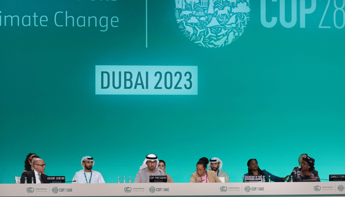 COP28 president Sultan Ahmed Al Jaber (C), UNFCCC Executive Secretary Simon Stiell (L) and other officials attend a plenary session during the UN climate summit in Dubai on December 13, 2023. — AFP