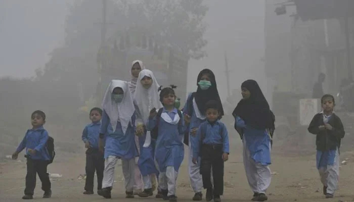 Children walking to school in heavy smog in Lahore. — AFP/File