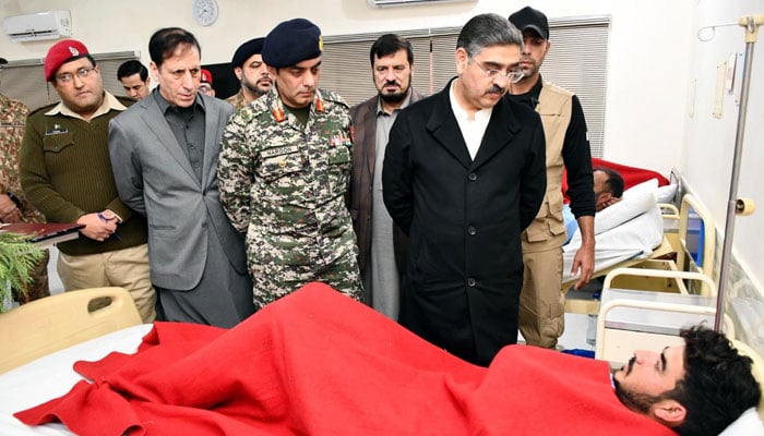 Caretaker Prime Minister Anwaar-ul-Haq Kakar enquires about the health of those injured in the Dera Ismail Khan blast during his visit to CMH  DIKHAN on December 13, 2023. — PID