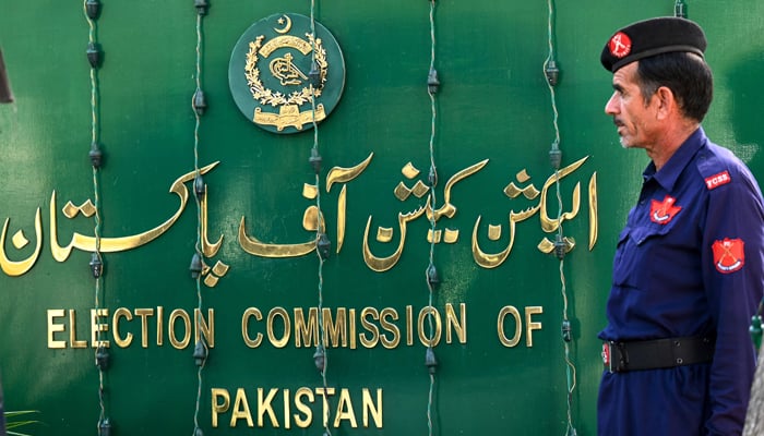 A security guard stands near the Election Commission of Pakistan (ECP) sign board in Islamabad. — AFP/File