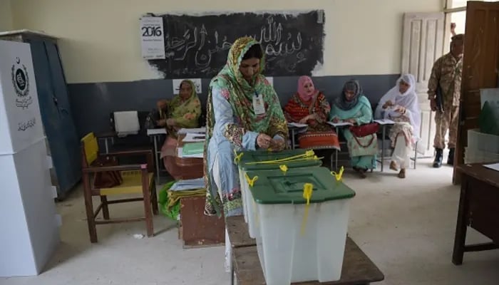 An election official seals ballot boxes before people vote during the general election at a polling station in Islamabad. — AFP/File