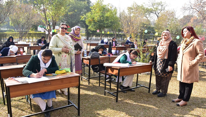 This image shows teachers standing as students are seen busy in an activity during the VNS Arts and Literature Festival on December 14, 2023. — Facebook/Viqar un Nisa Noon Girls Higher Secondary Institute