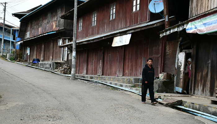 A resident walking along a quiet street in Namhsan Township amid clashes between the ethnic minority armed group Taang National Liberation Army (TNLA) and Myanmars military in northern Shan State on  December 12, 2023. — AFP