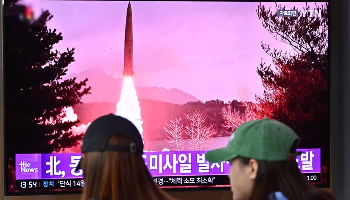 People watch a television screen showing a news broadcast with file footage of a North Korean missile test, in Seoul on September 13, 2023. — AFP