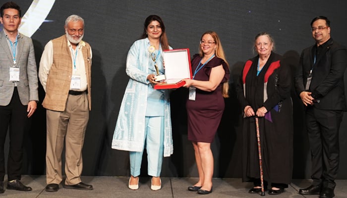 Beenish Saeed (c), a school principal in Multan receives an award the ‘Principal of the Year’ award by the Asia Education Conclave in this image released on December 11, 2023. — Facebook/Asia Education Conclave