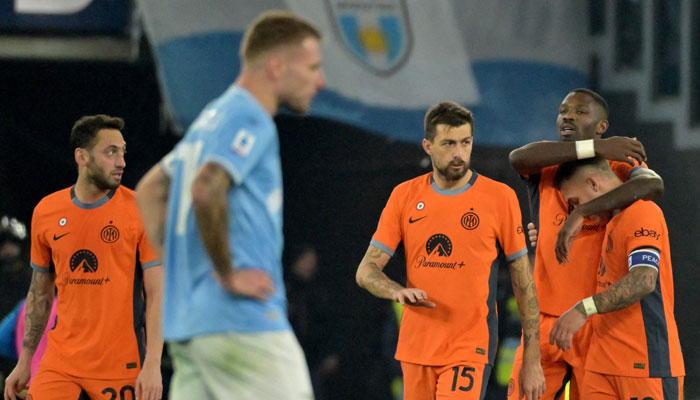 Marcus Thuram celebrates with teammates Inter Milans Francesco Acerbi and Inter Milans Lautaro Martinez after scoring the teams second goal during the Italian Serie A football match Lazio vs Inter Milan at the Olympic stadium in Rome on December 17, 2023. — AFP