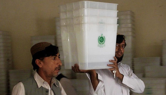 Election commission workers carry ballot boxes.— INP/File