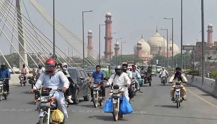 Commuters make their way along a street in Lahore. — AFP/File