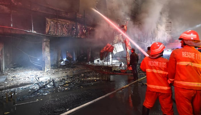 Firefighters extinguish fire erupt a six-storey apartment building in Karachi’s FB Area. — INP/File