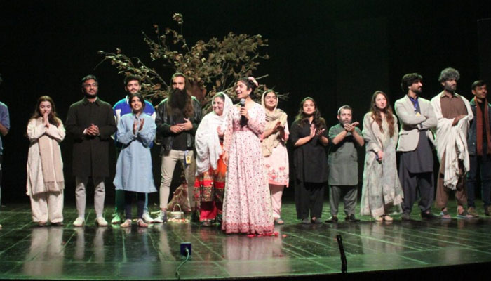 Drama artist stands on the stage after performing a drama at Quaid-e-Azam University Islamabad on December 23, 2023. — APP