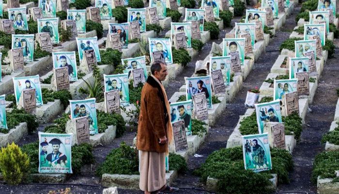 A man stands between the graves of people killed during the war in Yemen, at a cemetery in the Houthi-held capital Sanaa. — AFP