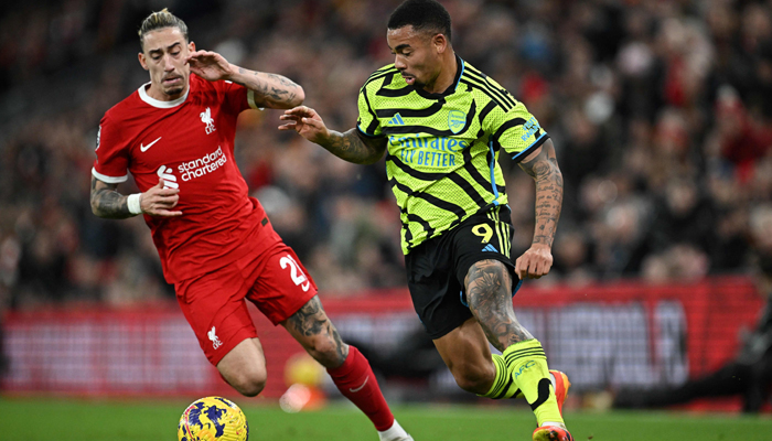 Liverpools Kostas Tsimikas (L) fights for the ball with Darwin Nunez during the English Premier League football match between Liverpool and Arsenal at Anfield in Liverpool, on December 23, 2023. — AFP