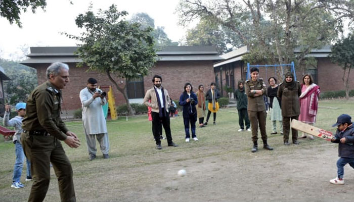 IG Punjab Dr Usman Anwar plays cricket with the orphans at SOS Village Sports Ground on December 24, 2023. —Facebook/Punjab Police Pakistan