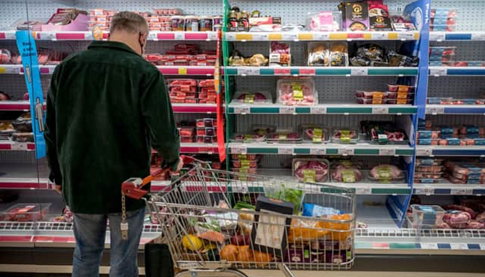 A person buys groceries in a store. — AFP/File