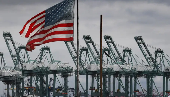 THe US flag flutters over a commercial port in the US. — AFP/File