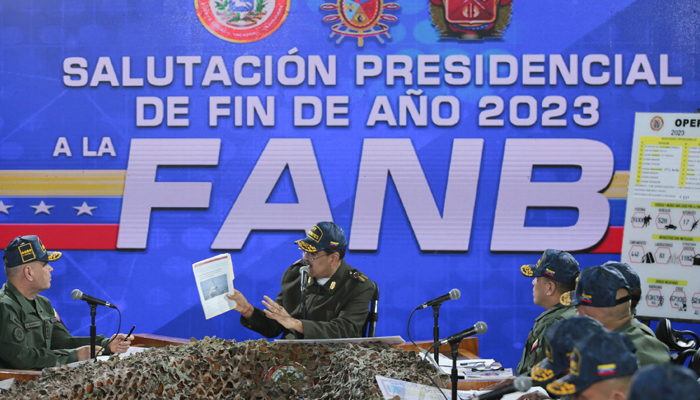 Venezuelas President Nicolas Maduro (C) delivering a speech next to Venezuelan Defense Minister Vladimir Padrino Lopez (L) during a meeting with members of the Bolivarian National Armed Forces (FANB) in Caracas, on December 28, 2023. — AFP