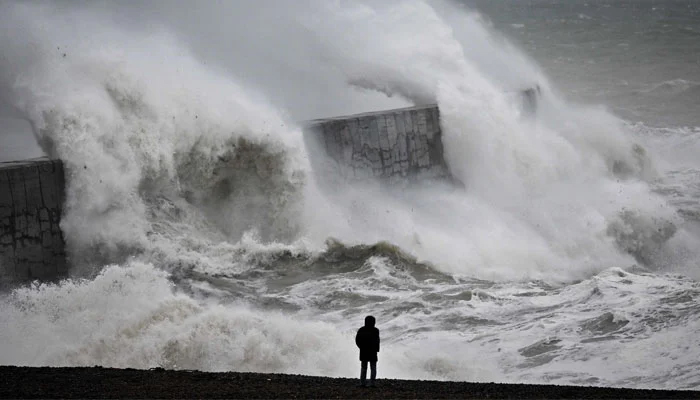 Waves crash the harbour wall with strong winds and heavy rain. — AFP