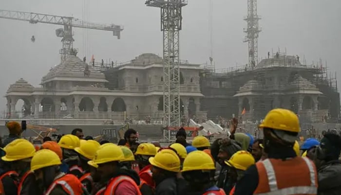 Workers gather at the construction site of a temple to Hindu deity Ram, in Ayodhya on December 29, 2023. - AFP