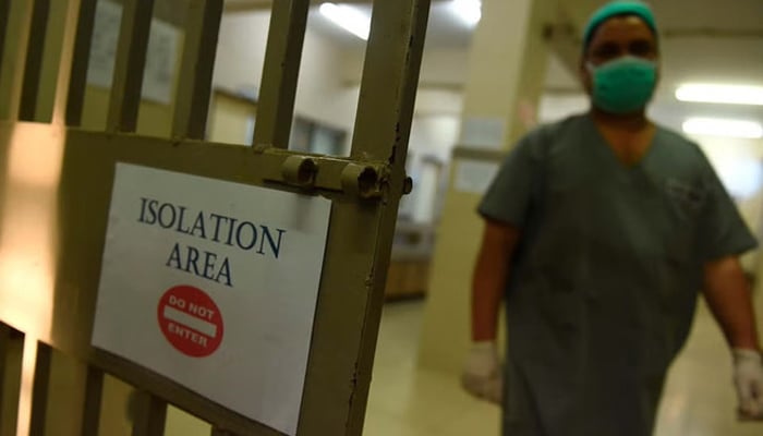 A medical staff member wearing a protective facemask walks into an isolation ward at the Jinnah Post Graduate Medical Center (JPMC) in Karachi on February 3, 2020. — AFP