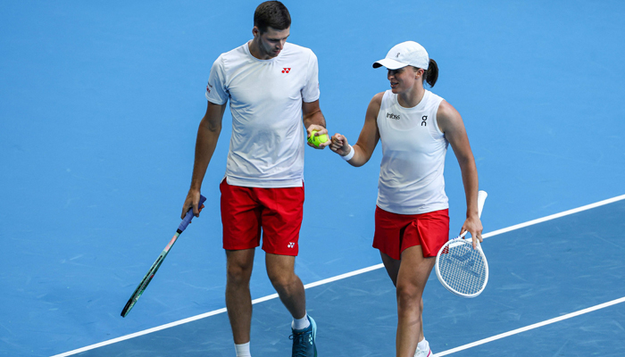 Polands Iga Swiatek speaks to partner Hubert Hurkacz during their mixed doubles match against Spains Sara Sorribes Tormo and Alejandro Davidovich Fokina at the United Cup tennis tournament in Perth on January 1, 2024. — AFP