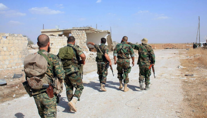 Syrian army soldiers walk around Kweyris military airport in the eastern Aleppo province. — AFP/File