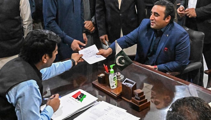 Pakistan Peoples Party chairman Bilawal Bhutto Zardari (R) submits his nomination papers at the deputy commissioner office in Shahdad Kot of Sindh on December 24, 2023. — AFP